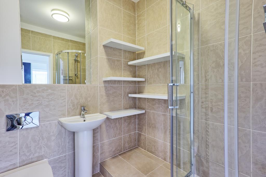 Lot: 6 - ATTRACTIVE TWO-BEDROOM APARTMENT IN CONVERTED FORMER HOSPITAL BUILDING - Shower room with toilet, sink and step in shower with shelves